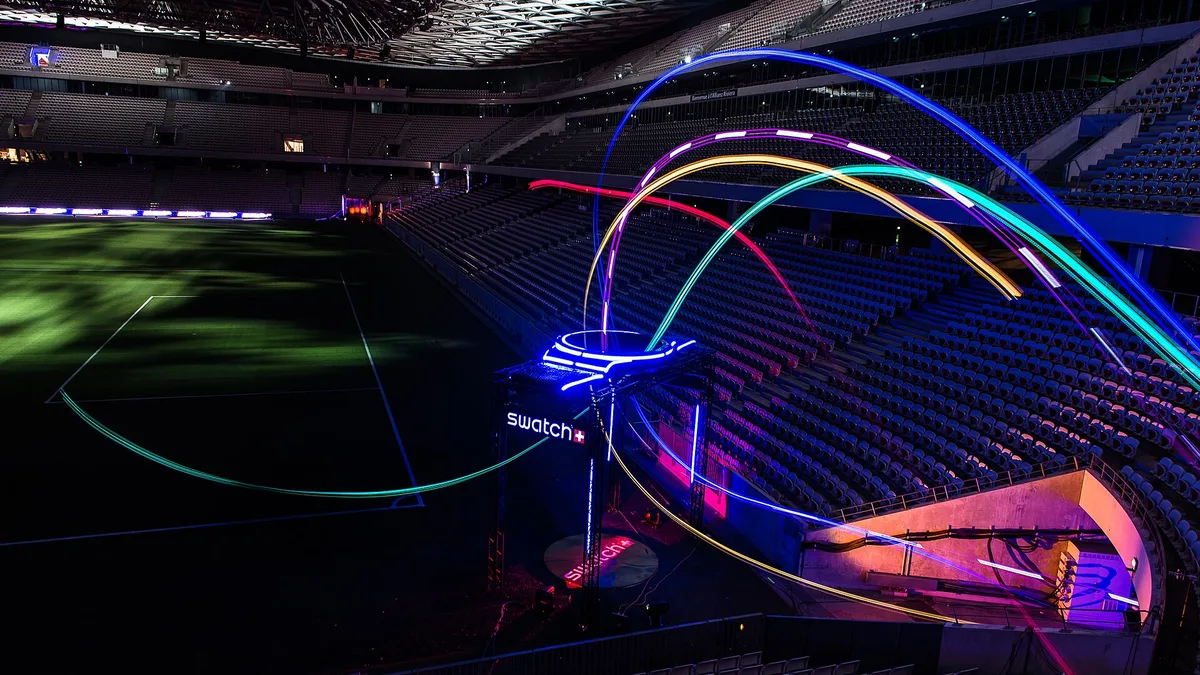 Drones de course traversant une porte lumineuse dans un stade