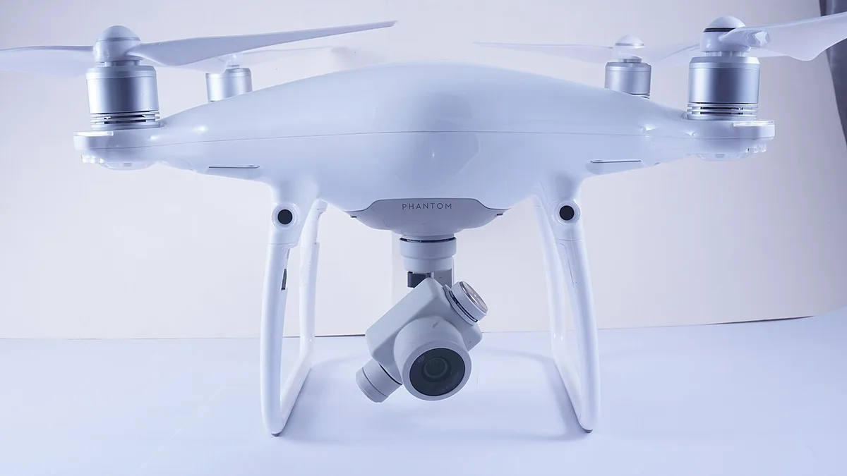 Drone DJI Phantom 4 Pro blanc, caméra sur nacelle, posé sur fond clair
