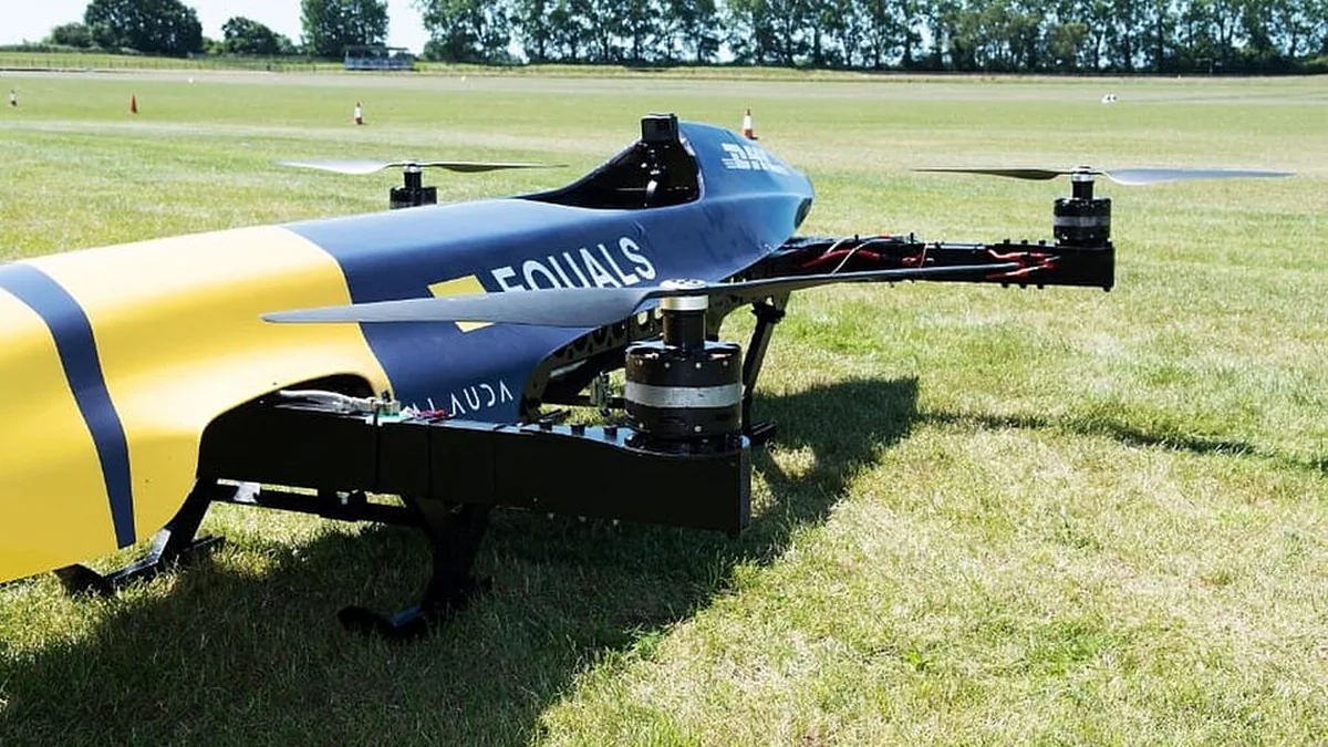 Voiture volante de course Airspeeder bleue et jaune posée sur l'herbe, rotors visibles